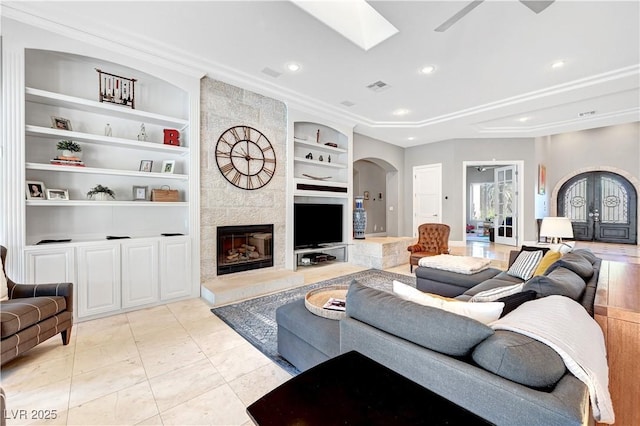 2111 Bogart Ct, Las Vegas, NV 89117 - living area featuring arched walkways, built in shelves, a high end fireplace, recessed lighting, and a skylight