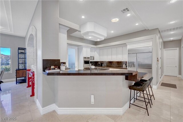 2111 Bogart Ct, Las Vegas, NV 89117 - kitchen featuring dark countertops, tasteful backsplash, a peninsula, oven, and recessed lighting