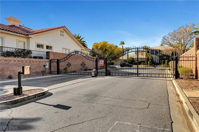 2111 Bogart Ct, Las Vegas, NV 89117 - view of asphalt road with a gate, a gated entry, and curbs