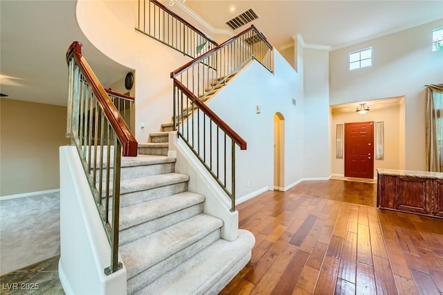 3412 Crystal Tower St, Las Vegas, NV 89129 - stairway with hardwood / wood-style floors, baseboards, a high ceiling, crown molding, and arched walkways