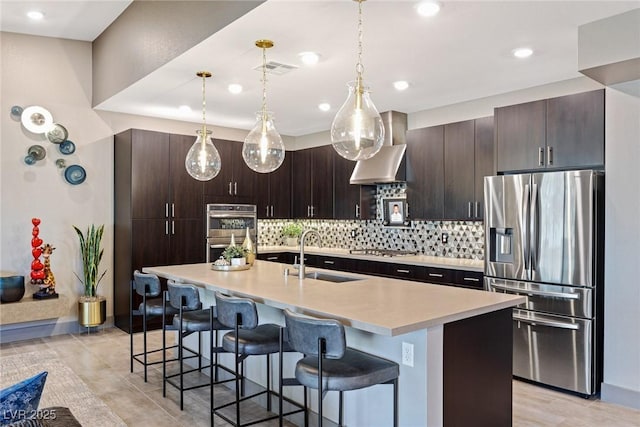 4290 Solace St, Las Vegas, NV 89135 - kitchen featuring appliances with stainless steel finishes, a sink, a breakfast bar, dark brown cabinets, and recessed lighting