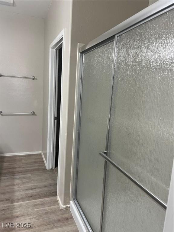6092 Fox Creek Ave, Las Vegas, NV 89122 - full bathroom with wood finished floors, a stall shower, and baseboards