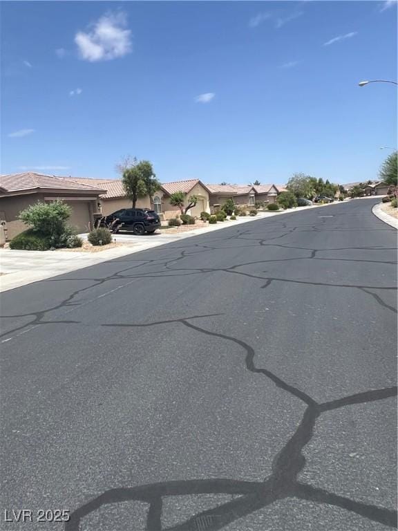 6092 Fox Creek Ave, Las Vegas, NV 89122 - view of asphalt road featuring street lighting and a residential view