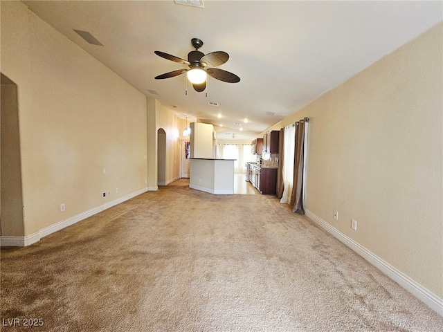 9462 Alhambra Valley St, Las Vegas, NV 89178 - unfurnished living room with arched walkways, light carpet, a ceiling fan, baseboards, and vaulted ceiling