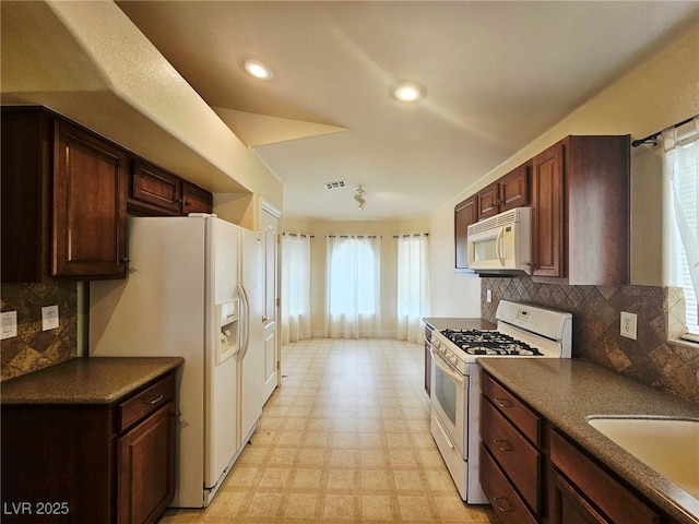 9462 Alhambra Valley St, Las Vegas, NV 89178 - kitchen with white appliances, dark countertops, light flooring, tasteful backsplash, and dark brown cabinets