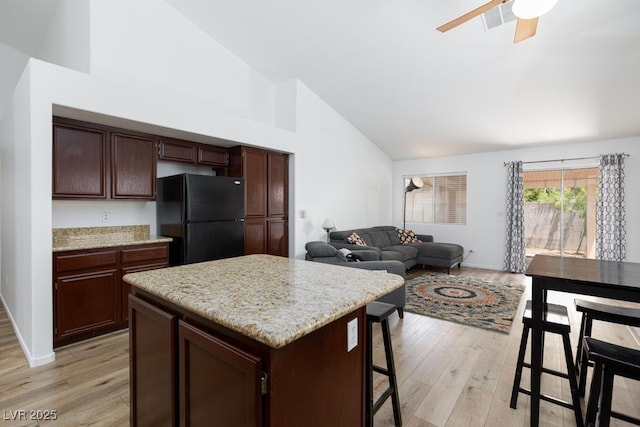 610 Playa Del Sol Way, Henderson, NV 89015 - kitchen featuring freestanding refrigerator, high vaulted ceiling, light wood-style floors, a kitchen island, and a kitchen breakfast bar