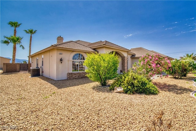 2851 Winchester Ave, Pahrump, NV 89048 - view of front facade with a chimney, central AC unit, stucco siding, and a tiled roof