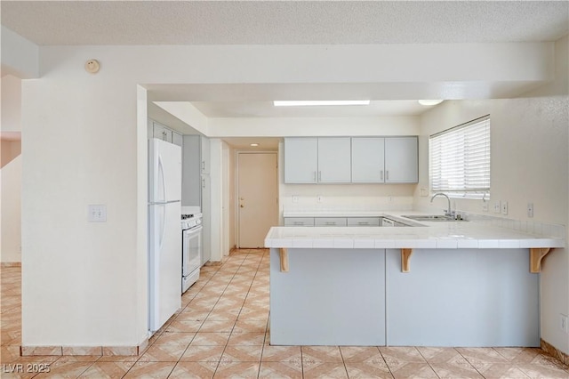 420 Clifton Heights Dr, Las Vegas, NV 89145 - kitchen featuring a sink, tile countertops, a peninsula, white appliances, and a breakfast bar
