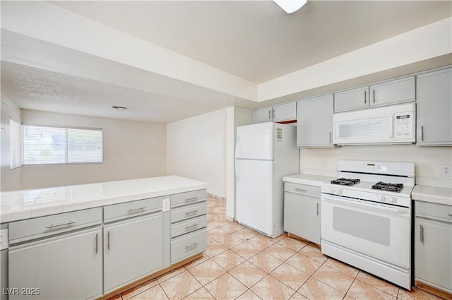 420 Clifton Heights Dr, Las Vegas, NV 89145 - kitchen featuring white appliances, gray cabinets, tile counters, and light tile patterned flooring