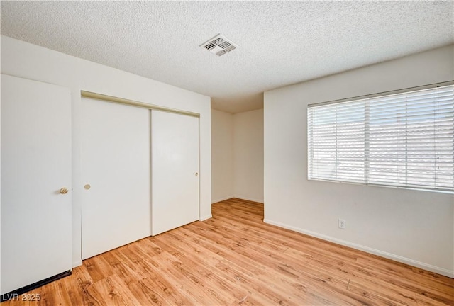 420 Clifton Heights Dr, Las Vegas, NV 89145 - unfurnished bedroom featuring light wood finished floors, a closet, a textured ceiling, and baseboards