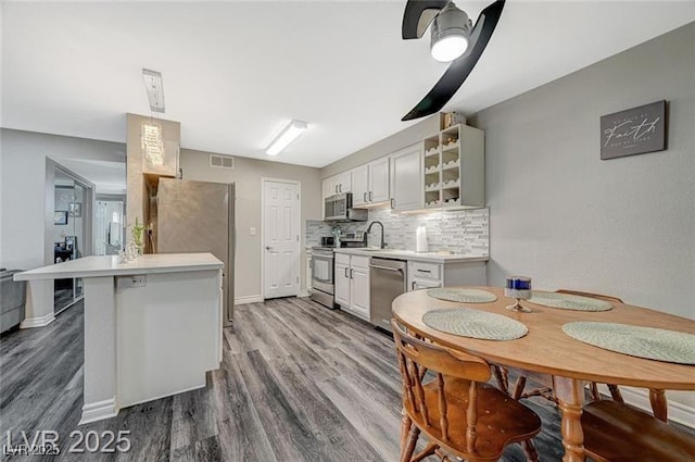 2451 N Rainbow Blvd Unit 2076, Las Vegas, NV 89108 - kitchen featuring appliances with stainless steel finishes, a sink, light countertops, and wood finished floors