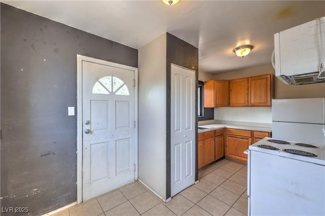 240 N 19th St, Las Vegas, NV 89101 - kitchen with white appliances, light tile patterned floors, light countertops, and brown cabinets