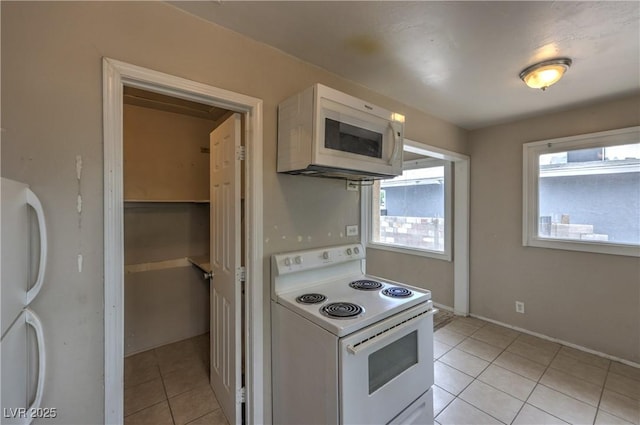 240 N 19th St, Las Vegas, NV 89101 - kitchen featuring white appliances, light tile patterned flooring, white cabinetry, and baseboards