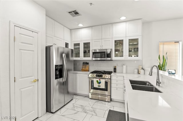 9613 Eland Ct, Las Vegas, NV 89149 - kitchen featuring stainless steel appliances, a sink, light marble finish floors, white cabinetry, and recessed lighting
