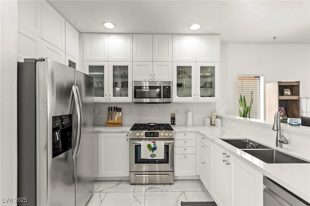 9613 Eland Ct, Las Vegas, NV 89149 - kitchen featuring appliances with stainless steel finishes, a sink, light marble finish flooring, light countertops, and white cabinetry