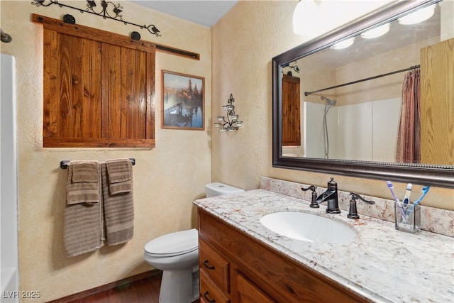 3008 Soledad Dr, Laughlin, NV 89029 - bathroom with a textured wall, vanity, toilet, a shower with shower curtain, and wood finished floors
