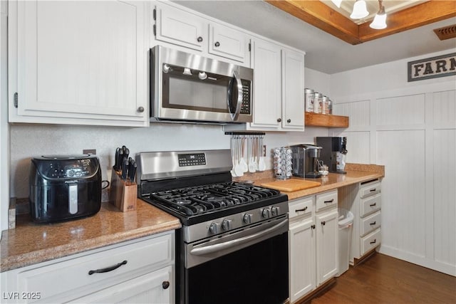 3008 Soledad Dr, Laughlin, NV 89029 - kitchen featuring appliances with stainless steel finishes, white cabinetry, dark wood finished floors, and light stone countertops