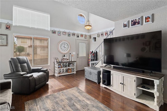 3008 Soledad Dr, Laughlin, NV 89029 - living room with stairway, dark wood-style flooring, a textured ceiling, and high vaulted ceiling