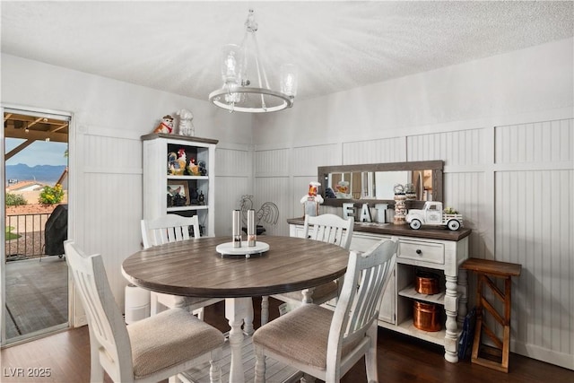 3008 Soledad Dr, Laughlin, NV 89029 - dining area with a chandelier, a decorative wall, wood finished floors, and a wainscoted wall