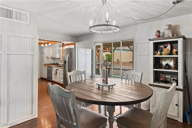 3008 Soledad Dr, Laughlin, NV 89029 - dining area featuring a chandelier, a textured ceiling, and dark wood-style floors