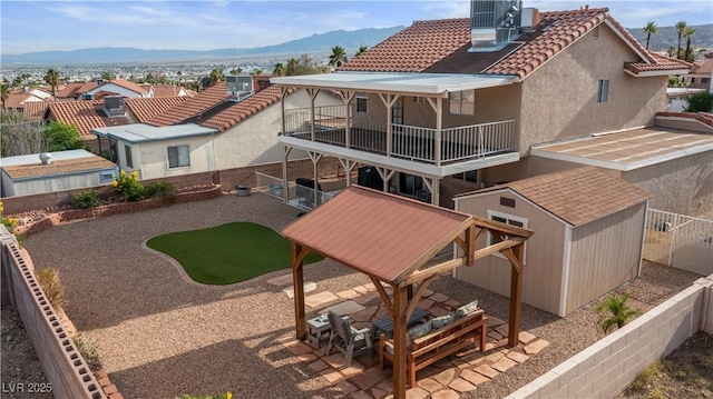 3008 Soledad Dr, Laughlin, NV 89029 - rear view of house with a fenced backyard, a balcony, central AC unit, and a mountain view