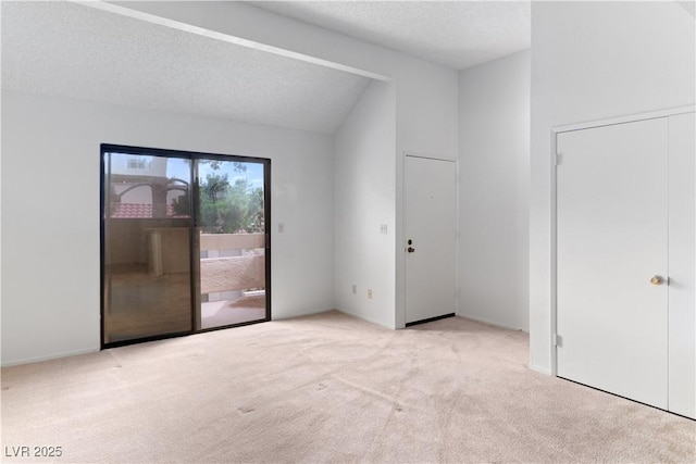 3740 Desert Marina Dr Unit 2, Laughlin, NV 89029 - unfurnished bedroom with access to exterior, carpet floors, vaulted ceiling, and a textured ceiling