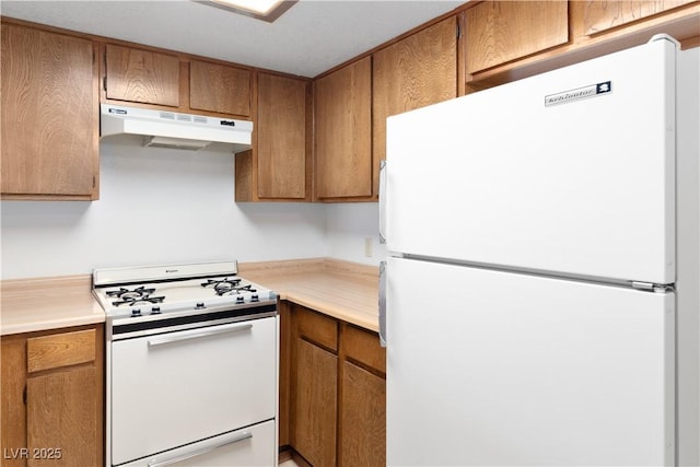3740 Desert Marina Dr Unit 2, Laughlin, NV 89029 - kitchen featuring white appliances, under cabinet range hood, light countertops, and brown cabinets