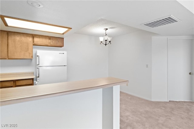 3740 Desert Marina Dr Unit 2, Laughlin, NV 89029 - kitchen with freestanding refrigerator, light colored carpet, light countertops, and pendant lighting