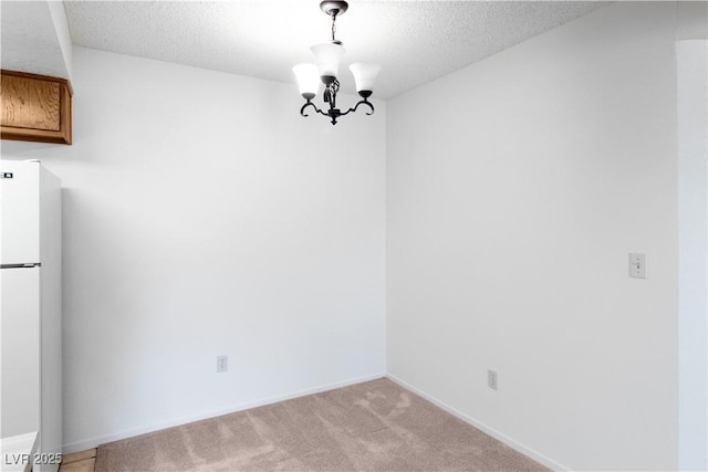 3740 Desert Marina Dr Unit 2, Laughlin, NV 89029 - unfurnished dining area with a chandelier, a textured ceiling, light carpet, and baseboards