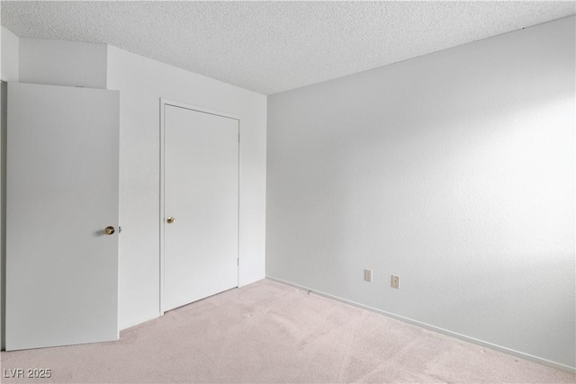 3740 Desert Marina Dr Unit 2, Laughlin, NV 89029 - unfurnished bedroom featuring light colored carpet, a textured ceiling, and a closet