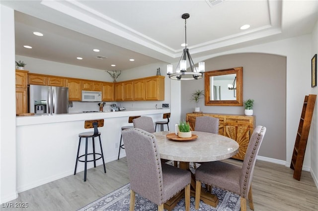 9112 Vista Greens Way Unit 204, Las Vegas, NV 89134 - dining space featuring a chandelier, light wood-style flooring, recessed lighting, baseboards, and a raised ceiling