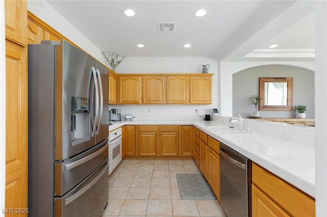 9112 Vista Greens Way Unit 204, Las Vegas, NV 89134 - kitchen featuring appliances with stainless steel finishes, a sink, recessed lighting, light tile patterned floors, and arched walkways