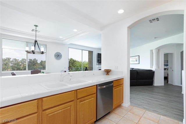 9112 Vista Greens Way Unit 204, Las Vegas, NV 89134 - kitchen with stainless steel dishwasher, a sink, arched walkways, light tile patterned floors, and a chandelier