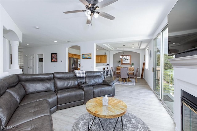 9112 Vista Greens Way Unit 204, Las Vegas, NV 89134 - living room featuring light wood finished floors, a glass covered fireplace, arched walkways, ceiling fan, and recessed lighting
