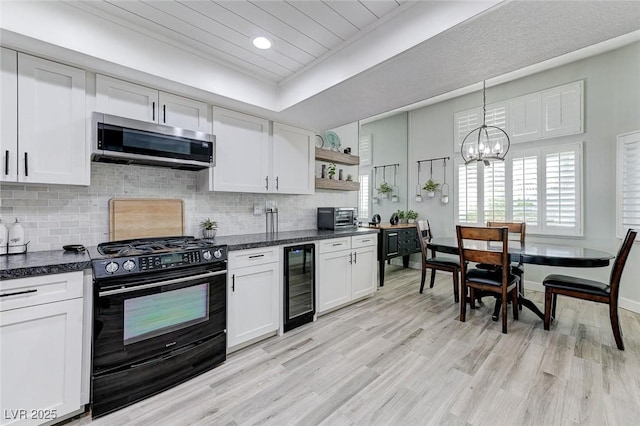 450 Intrepid Ct, Boulder City, NV 89005 - kitchen with black range with gas stovetop, stainless steel microwave, wine cooler, white cabinets, and recessed lighting