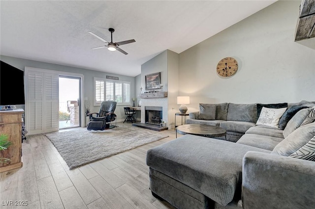 450 Intrepid Ct, Boulder City, NV 89005 - living area featuring vaulted ceiling, a ceiling fan, light wood finished floors, and a fireplace with raised hearth