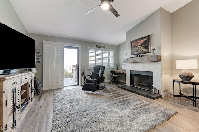 450 Intrepid Ct, Boulder City, NV 89005 - living area featuring vaulted ceiling, a ceiling fan, a brick fireplace, wood finished floors, and baseboards