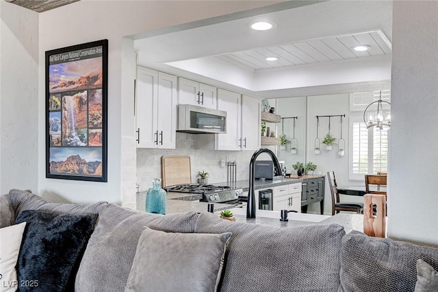 450 Intrepid Ct, Boulder City, NV 89005 - kitchen featuring stainless steel appliances, open floor plan, a chandelier, white cabinets, and backsplash