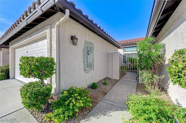 450 Intrepid Ct, Boulder City, NV 89005 - view of side of property featuring stucco siding, a garage, a gate, and a tile roof