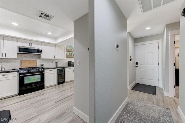 450 Intrepid Ct, Boulder City, NV 89005 - kitchen with black gas stove, wine cooler, stainless steel microwave, dark countertops, and baseboards