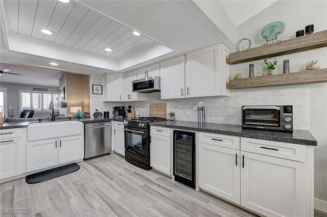 450 Intrepid Ct, Boulder City, NV 89005 - kitchen with stainless steel appliances, beverage cooler, a raised ceiling, a sink, and white cabinetry