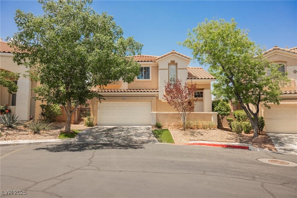 2057 Wandering Doe Ln, Las Vegas, NV 89134 - mediterranean / spanish house featuring a tiled roof, stucco siding, concrete driveway, and a garage