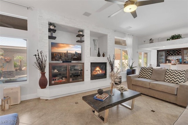 4108 Royal Scots Ave, Las Vegas, NV 89141 - tiled living room featuring a ceiling fan, a fireplace, baseboards, and a dry bar