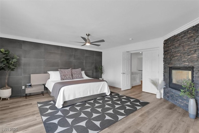 4108 Royal Scots Ave, Las Vegas, NV 89141 - bedroom featuring ornamental molding, wood finished floors, a stone fireplace, tile walls, and a ceiling fan