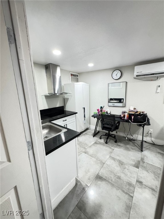 1505 Lilac Breeze Cir, Las Vegas, NV 89108 - kitchen featuring wall chimney range hood, a wall unit AC, dark countertops, a sink, and white cabinetry