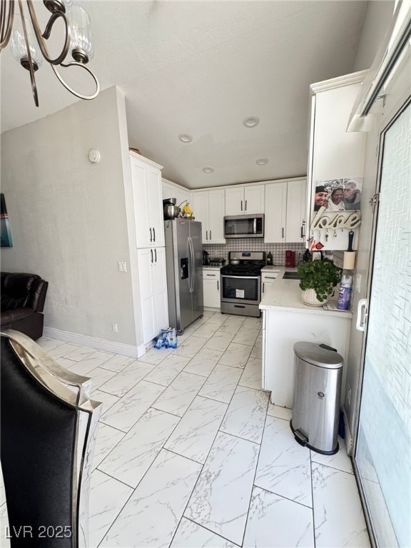 1505 Lilac Breeze Cir, Las Vegas, NV 89108 - kitchen featuring stainless steel appliances, white cabinets, light marble finish floors, light countertops, and recessed lighting