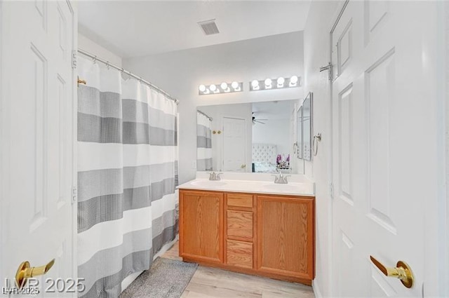6320 Desert Leaf St Unit 101, North Las Vegas, NV 89081 - bathroom with wood finished floors, a ceiling fan, double vanity, and a shower with curtain