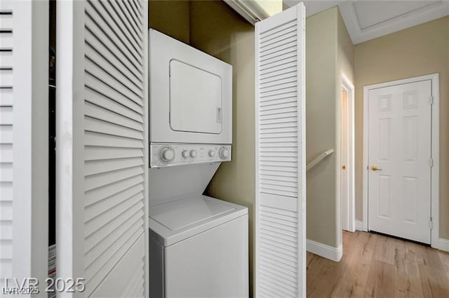 6320 Desert Leaf St Unit 101, North Las Vegas, NV 89081 - laundry room featuring stacked washer and clothes dryer, light wood-type flooring, baseboards, and attic access