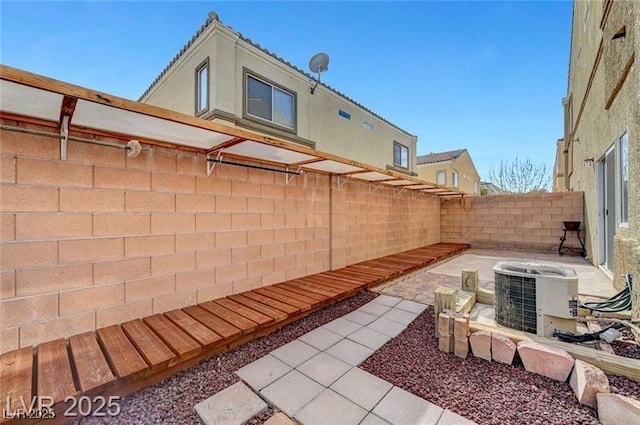 6320 Desert Leaf St Unit 101, North Las Vegas, NV 89081 - fenced backyard featuring cooling unit and a patio area