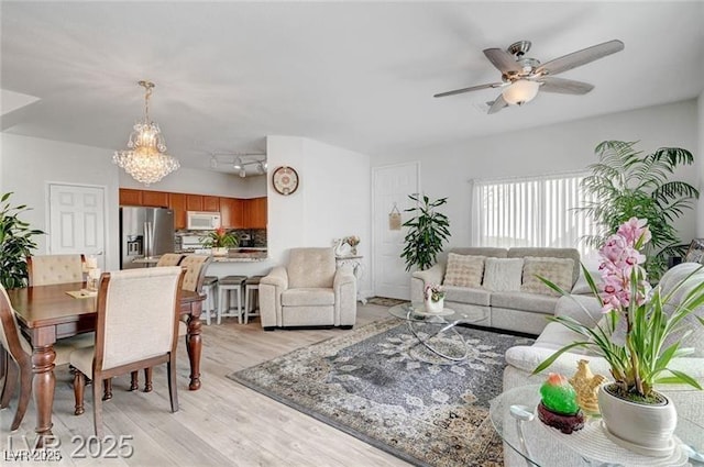6320 Desert Leaf St Unit 101, North Las Vegas, NV 89081 - living room with light wood finished floors, ceiling fan, and a chandelier